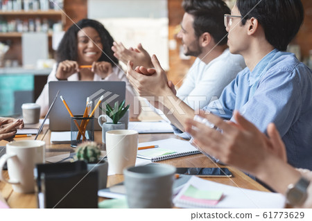 Young business team clapping hands on meeting, close up Young business team clapping hands on meeting, close up 61773629
