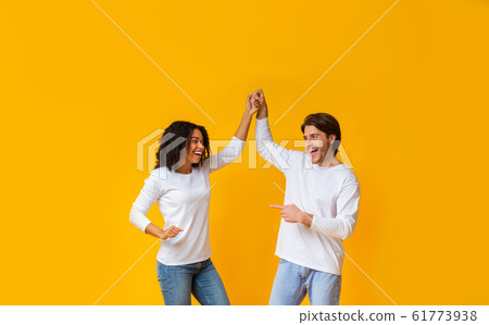 Cheerful Interracial Couple Fooling Together, Holding Hands And Dancing 61773938