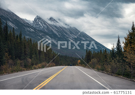 Road trip with Rocky mountains in autumn forest on 61775131