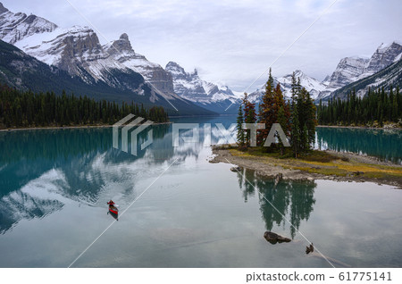 Traveler canoeing in Canadian rockies reflection Traveler canoeing in Canadian rockies reflection 61775141