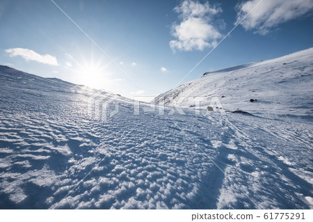 Snowy hill with sunlight and blue sky on winter at 61775291