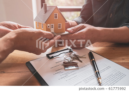 House model with agent and customer discussing for contract to buy, get insurance or loan estate. 61775992