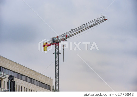 Crane near the brick high-rise building under 61776848