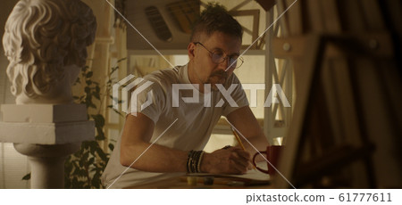 Artist drawing at table 61777611