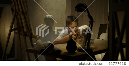 Young artist eating in studio 61777618