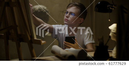 Boy using smartphone and drawing Boy using smartphone and drawing 61777629