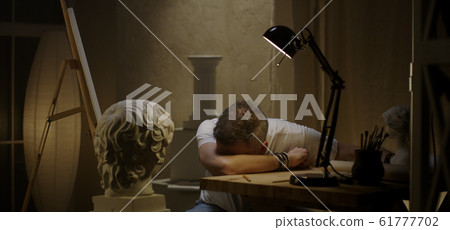Exhausted artist oversleeps in studio Exhausted artist oversleeps in studio 61777702