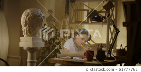 Young artist drawing at table 61777763