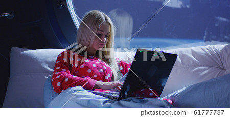 Woman using laptop in a spaceship 61777787