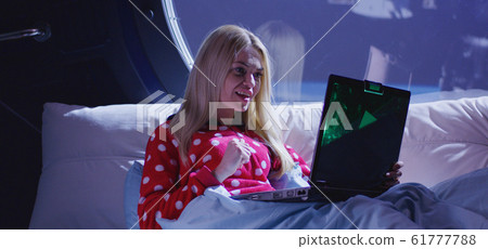 Woman using laptop in a spaceship Woman using laptop in a spaceship 61777788