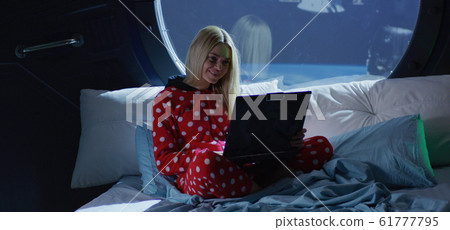 Woman having video call in a spaceship Woman having video call in a spaceship 61777795