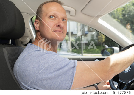 Man sitting in new modern car, dreaming and looking away  61777876
