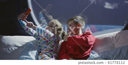 Boy and girl taking selfie in a spaceship Boy and girl taking selfie in a spaceship 61778112