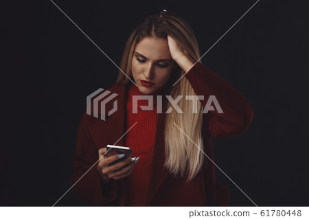Sad woman in stress with phone isolated in the dark room. Sad woman in stress with phone isolated in the dark room. 61780448