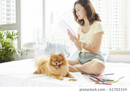 Young woman living with small dog 61783334