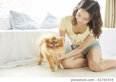 Young woman living with small dog 61783354