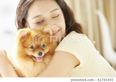 Young woman living with small dog 61783393