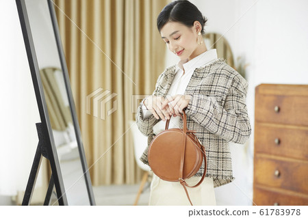 A woman dressed up in her room A woman dressed up in her room 61783978