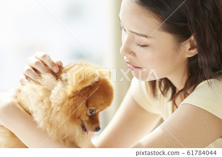 和小狗一起生活的年輕女子 61784044