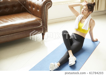 Young woman training in her room 61784203