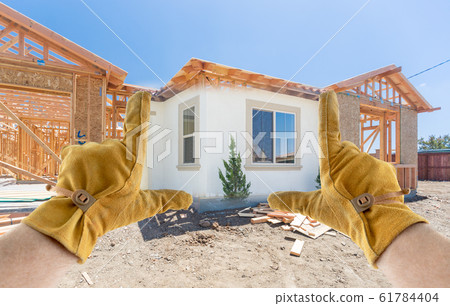 Male Contractor Hands Framing Completed Section of Construction Sketch 61784404