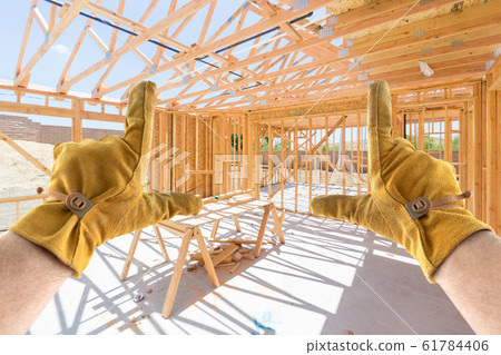 Male Contractor Hands Framing Unfinished House Construction Male Contractor Hands Framing Unfinished House Construction 61784406