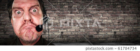 Grumpy Businessman with Frowning Face Wearing Headset 61784734