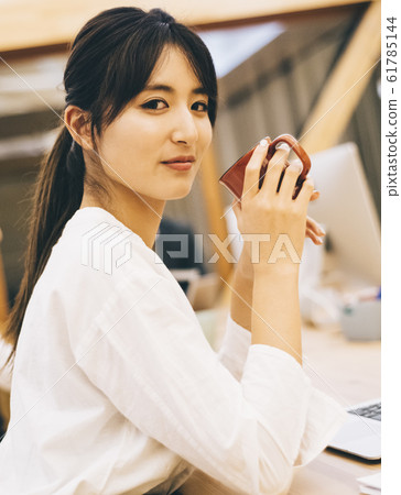 Business woman drinking coffee between work 61785144
