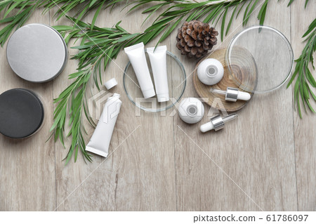 Cosmetic bottle containers packaging with green herbal leaves. 61786097