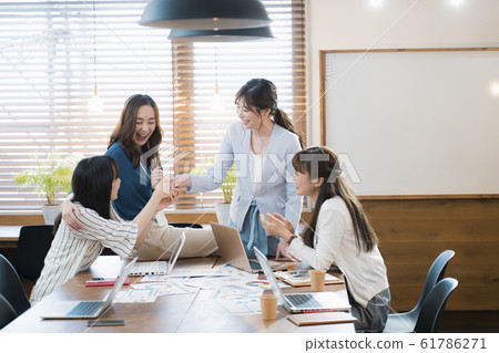一個女性業務團隊為成功而高興 一個女性業務團隊為成功而高興 61786271