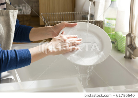 Young woman washing dishes at hand kitchen housework Young woman washing dishes at hand kitchen housework 61786640