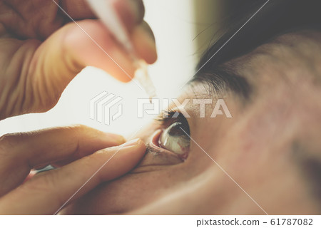 Woman use eye drop, artificial tears to the eye Woman use eye drop, artificial tears to the eye 61787082
