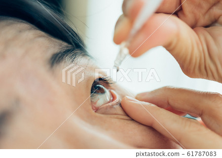 Woman use eye drop, artificial tears to the eye Woman use eye drop, artificial tears to the eye 61787083
