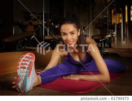 Young adult attractive woman doing stretching Young adult attractive woman doing stretching 61790473