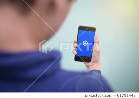 the GetContact logo on the smartphone screen close-up. phone in the hands of a young man 61791442