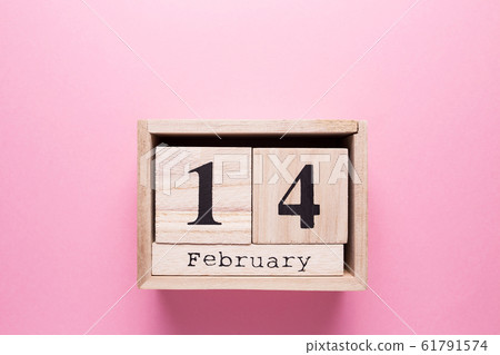 Wooden calendar with the inscription February 14 on a pink isolated background. 61791574