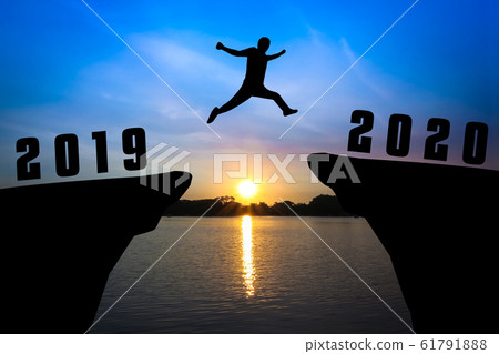 Silhouette young man jumping from 2019 to 2020 61791888