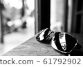 Single simple sun glasses on the wooden table with 61792902