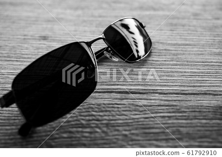 Single simple sun glasses on the wooden table with Single simple sun glasses on the wooden table with 61792910