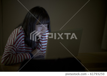 一個孩子在晚上看電腦 一個孩子在晚上看電腦 61793250