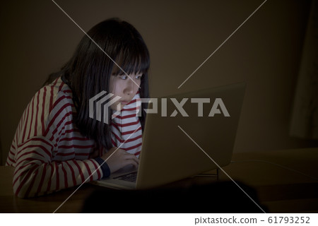 一個孩子在晚上看電腦 一個孩子在晚上看電腦 61793252