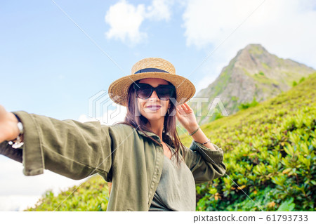 Beautiful happy young woman in mountains in the background of fog 61793733