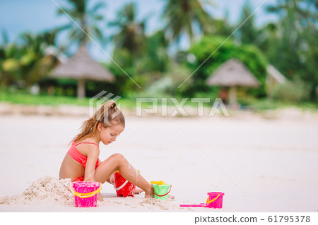 Adorable little girl playing with beach toys during tropical vacation 61795378