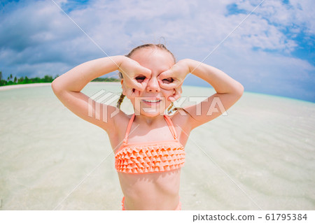 Cute little girl at beach during summer vacation 61795384