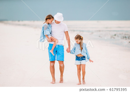 Happy beautiful family of dad and kids on white beach 61795395