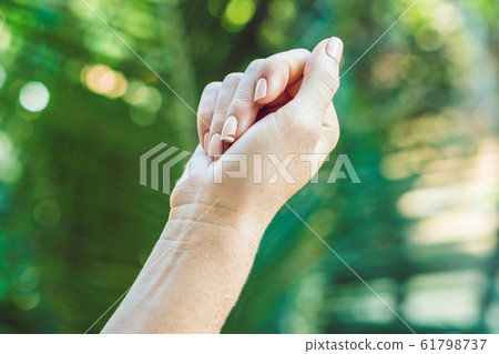 Broken nail on a woman's hand with a manicure on a green background Broken nail on a woman's hand with a manicure on a green background 61798737
