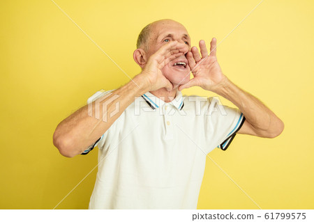 Caucasian senior man's portrait isolated on yellow studio background Caucasian senior man's portrait isolated on yellow studio background 61799575