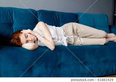 Young woman lying on couch and suffering from headache at home. Young woman lying on couch and suffering from headache at home. 61801429
