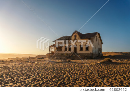 Sunrise above an abandoned house in Kolmanskop ghost town, Namibia 61802632