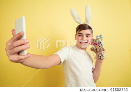 Easter bunny boy with bright emotions on yellow studio background Easter bunny boy with bright emotions on yellow studio background 61802833